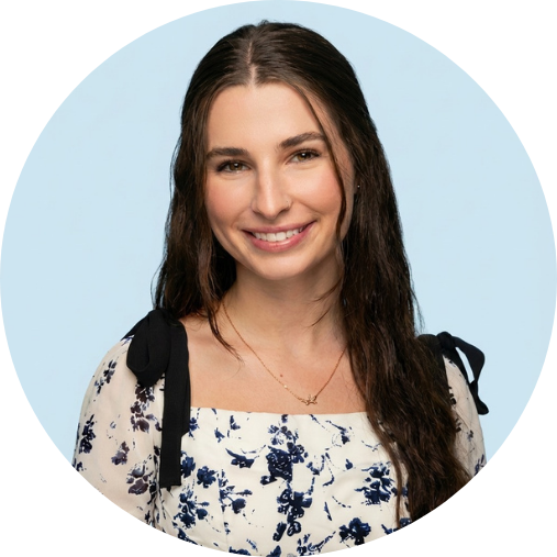 Smiling woman with long dark hair wearing a floral dress, circular crop against a light blue background
